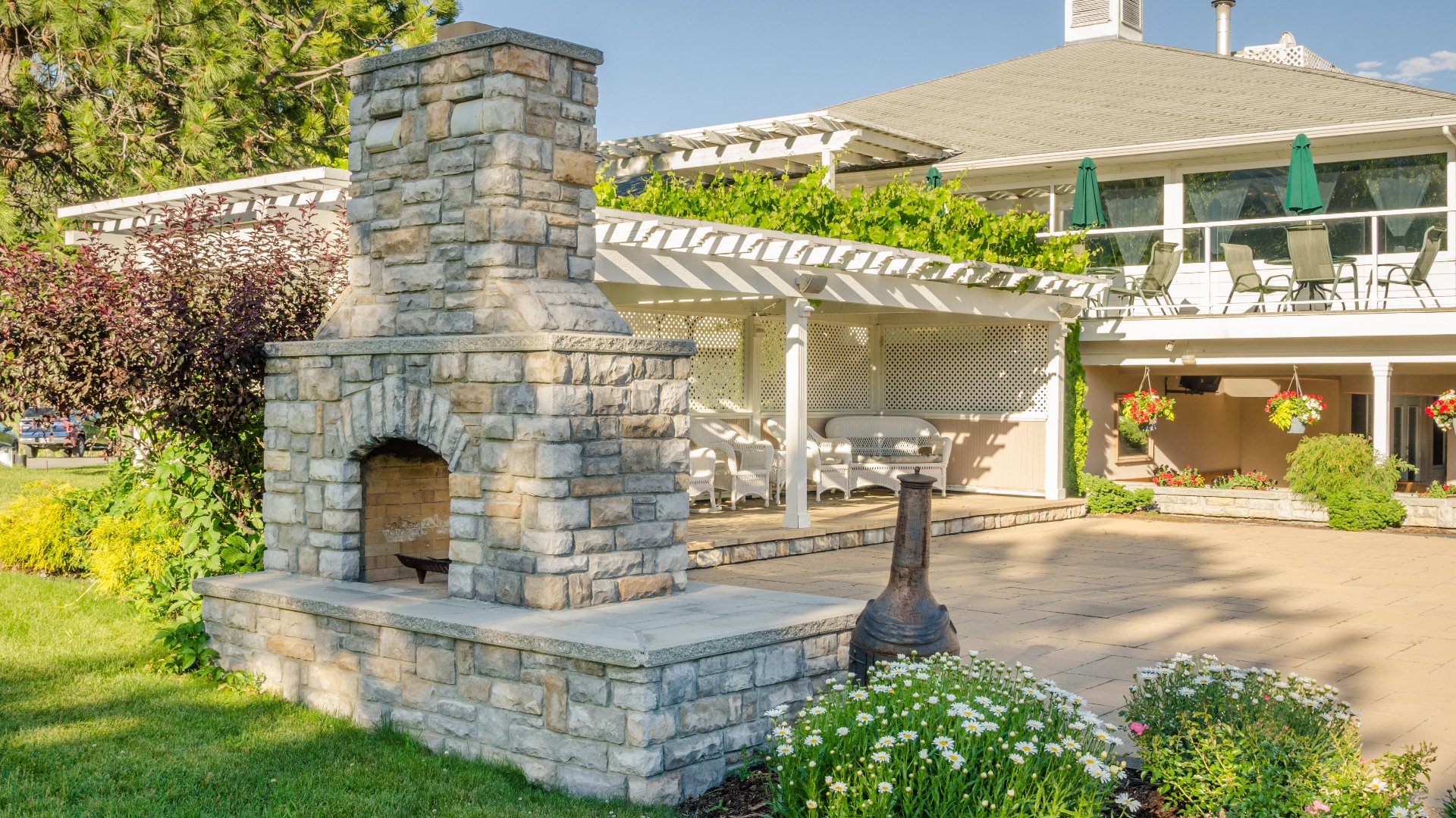 A custom built outdoor fireplace constructed by a pergola for our client in Madison Lake, MN.