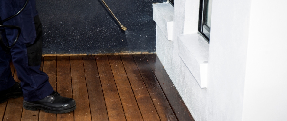 Professional applying perimeter pest control treatment to home in Mankato, MN.