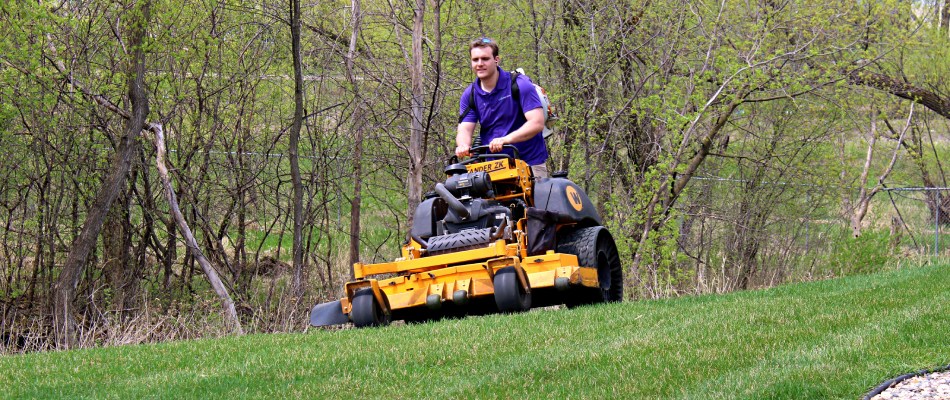 Lawn Crafters on riding mower servicing lawn in North Mankato, MN.