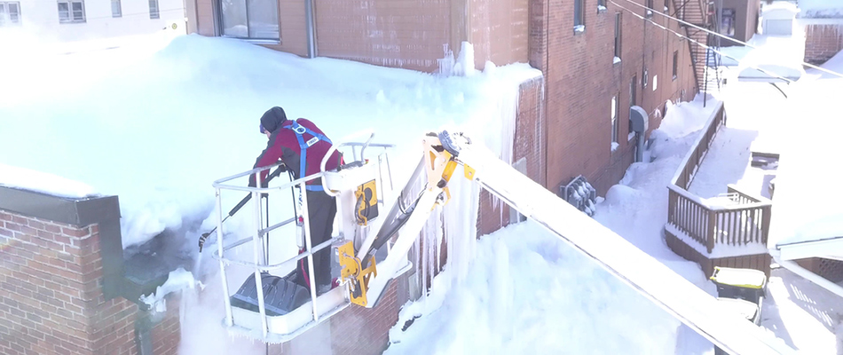 A professional assessing ice dam on a roof in Mankato, MN.