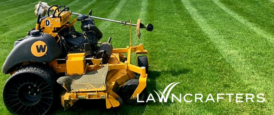 Yellow riding mower in lawn after mowing services in North Mankato, MN.